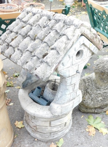 A reconstituted stone bird bath, with bird house top, on circular base, 91cm high, 50cm wide.
