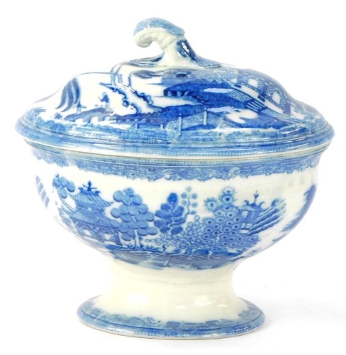 An early 19thC pearlware tureen and cover, printed in blue with the willow pattern, 21cm high.