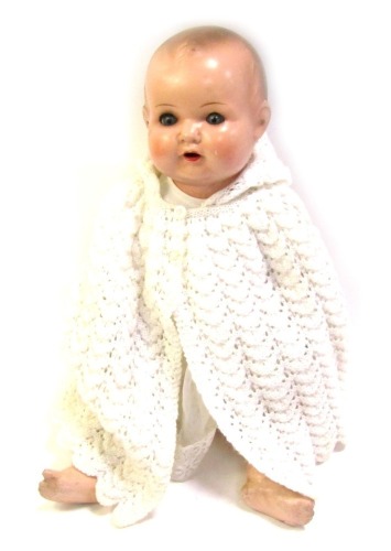 An Armand Marseille German bisque headed doll, marked 518./F.K., in a knitted and lace throw, with articulated limbs and roll eyes, 56cm high.