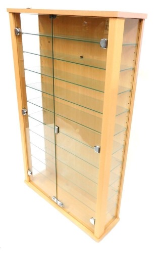 A beech collectors cabinet, with nine shelves and two swing doors, in a beech finish, 110cm high, 68cm wide, 20cm deep.