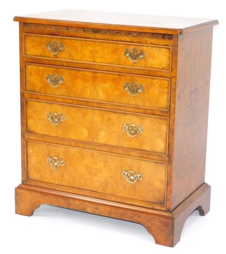 A burr elm batchelor's chest, with arrangement of four drawers and slide, with brass escutcheons and swing handle, on bracket feet, 76cm high, 65cm wide, 38cm deep.