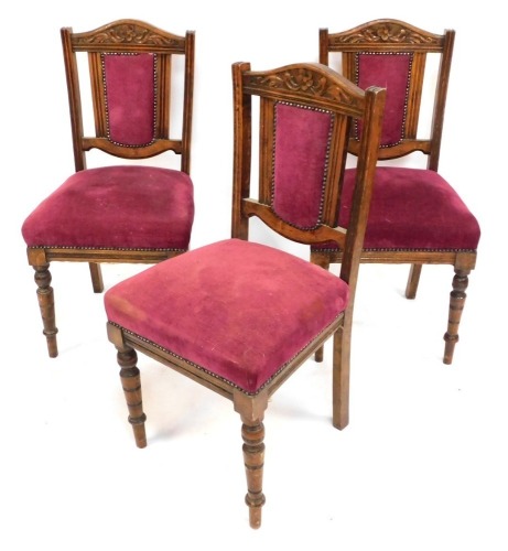 A set of three dining chairs, each with oak floral carved back and pink upholstered buttoned seat, each 94cm high.
