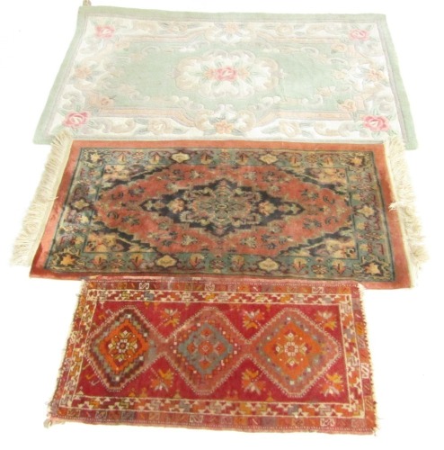 Two Caucasian prayer rugs, 86cm x 45cm and 121cm x 61cm respectively, and a Chinese rug, turquoise ground decorated with roses, 148cm x 89cm. (3)