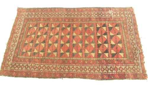 An Afghan rug, red ground decorated centrally with geometric motifs, within repeating floral and geometric borders, 139cm x 86cm.